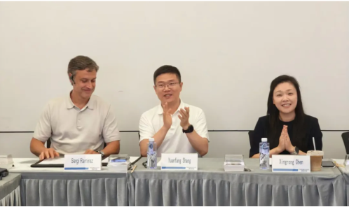 Three seated panelists at a conference table with name plates, left to right: Hanser Medical Biotech General Manager Sergi Ramirez, CellBri Founder, CEO Dr. Shang Yuanfang applauding, and Fosun Kairos CEO Chen Xingrong with hands clasped, during a business meeting